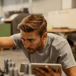 Professional man with beard working intently on laptop in modern office workspace