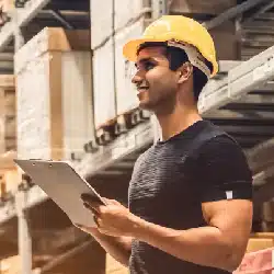 Construction worker in yellow hard hat reviewing documents at building site