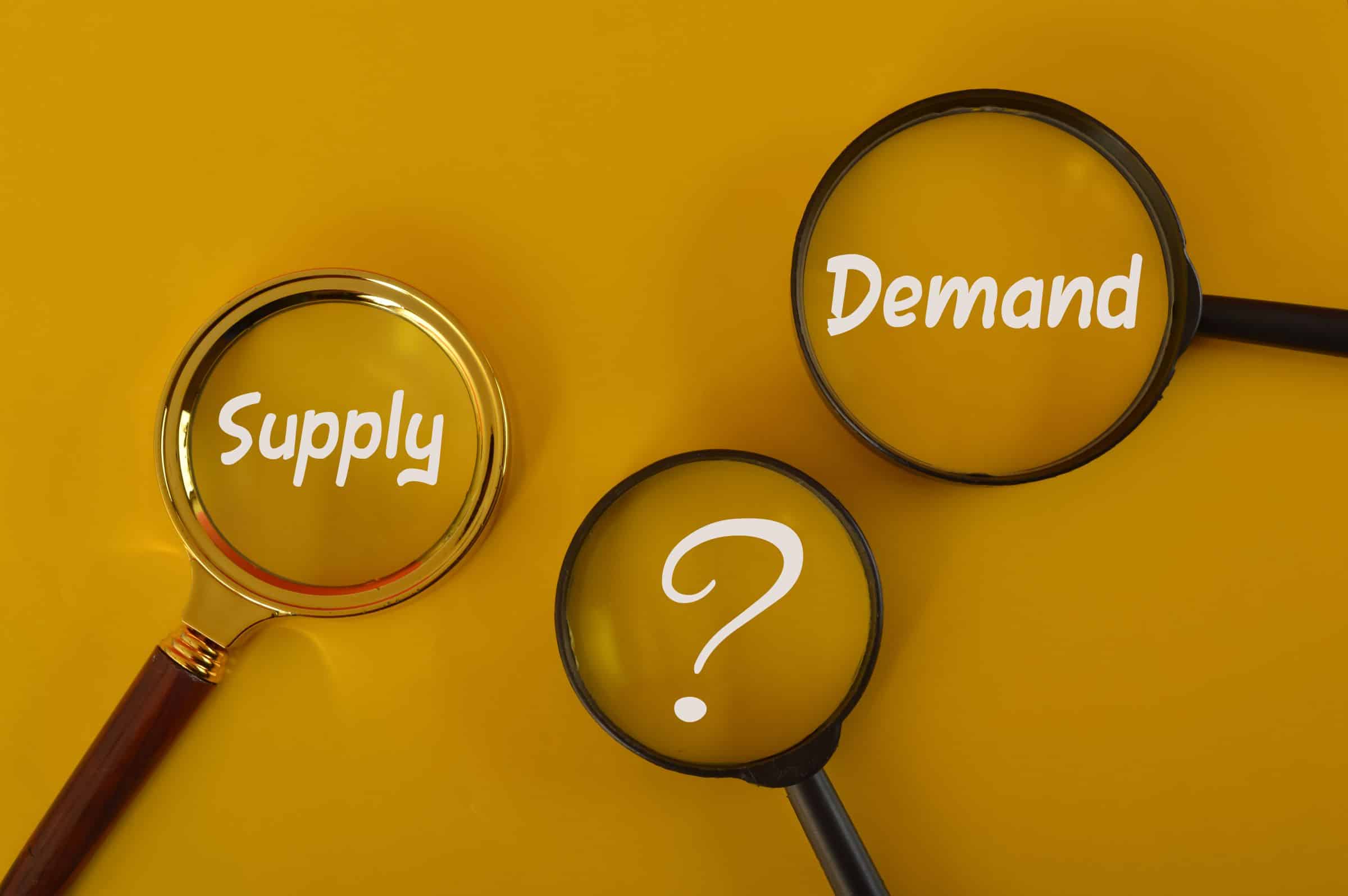 words supply and demand and a question mark under a magnifying glass