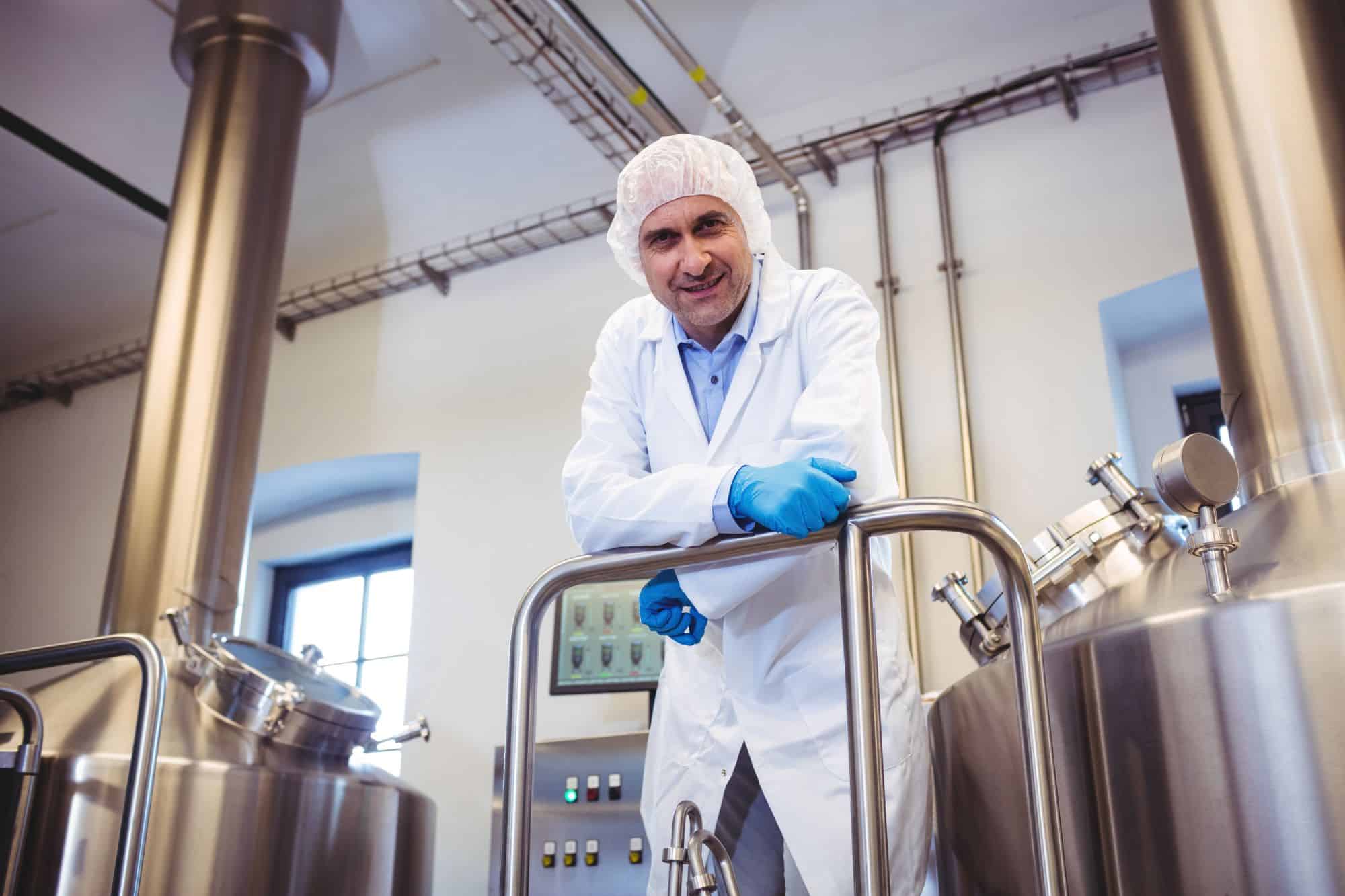 manufacturer leaning on pipe at brewery