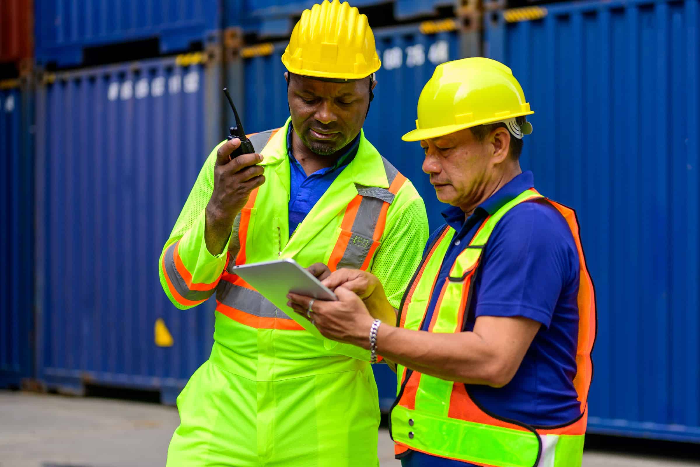 workers looking at a checklist in warehouse yard