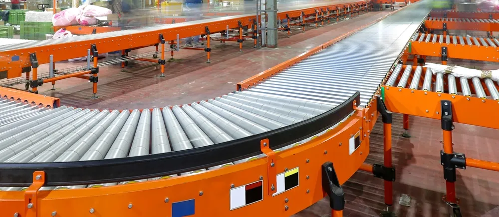 Modern orange conveyor belt system with rollers in warehouse distribution center