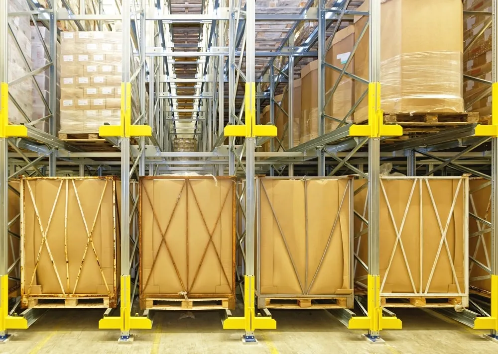 Modern automated warehouse storage system with yellow safety barriers and pallet racking
