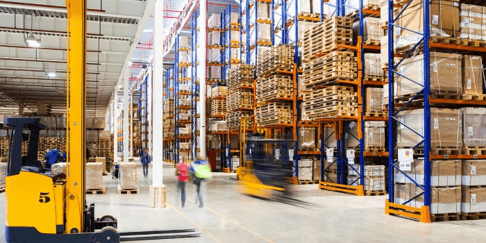 warehouse workers walking and a forklift in motion