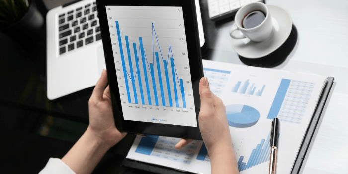 hands holding tablet with manufacturing inventory management software chart