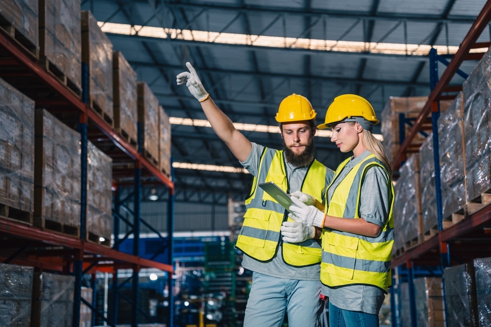 warehouse workers using manufacturing inventory management software tablet