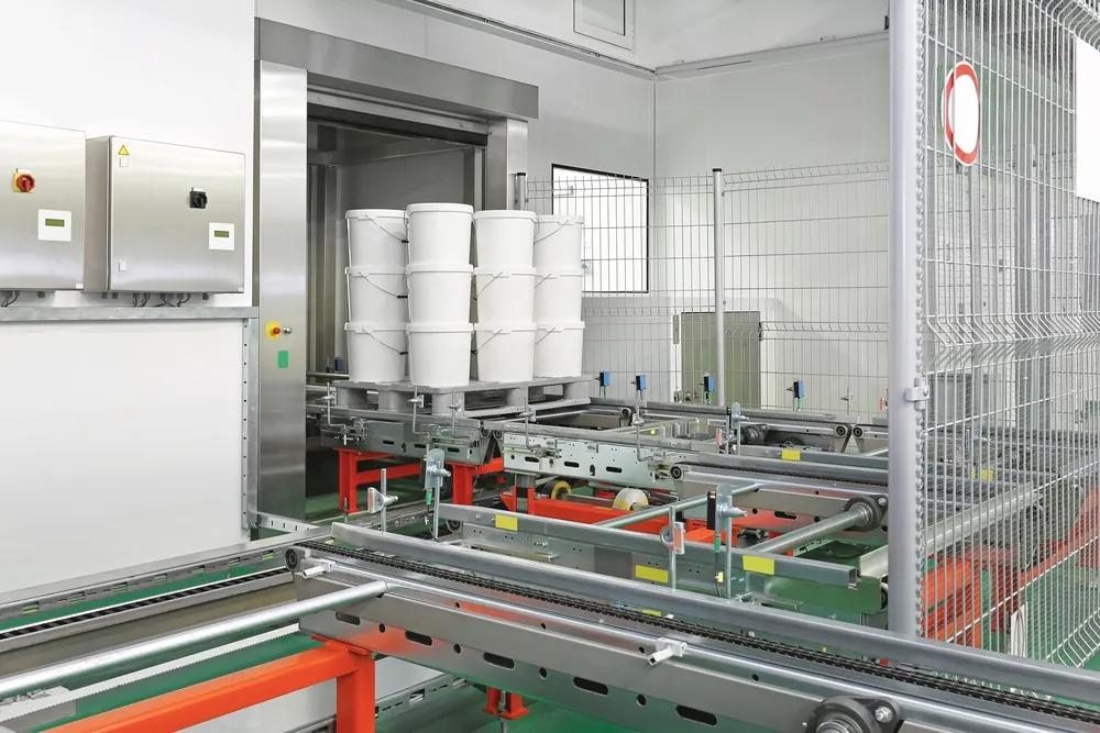 Automated storage and retrieval system handling white buckets on conveyor tracks in warehouse