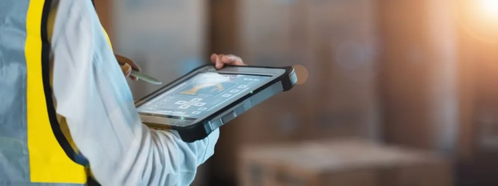 Warehouse worker using tablet device for inventory management and WMS operations