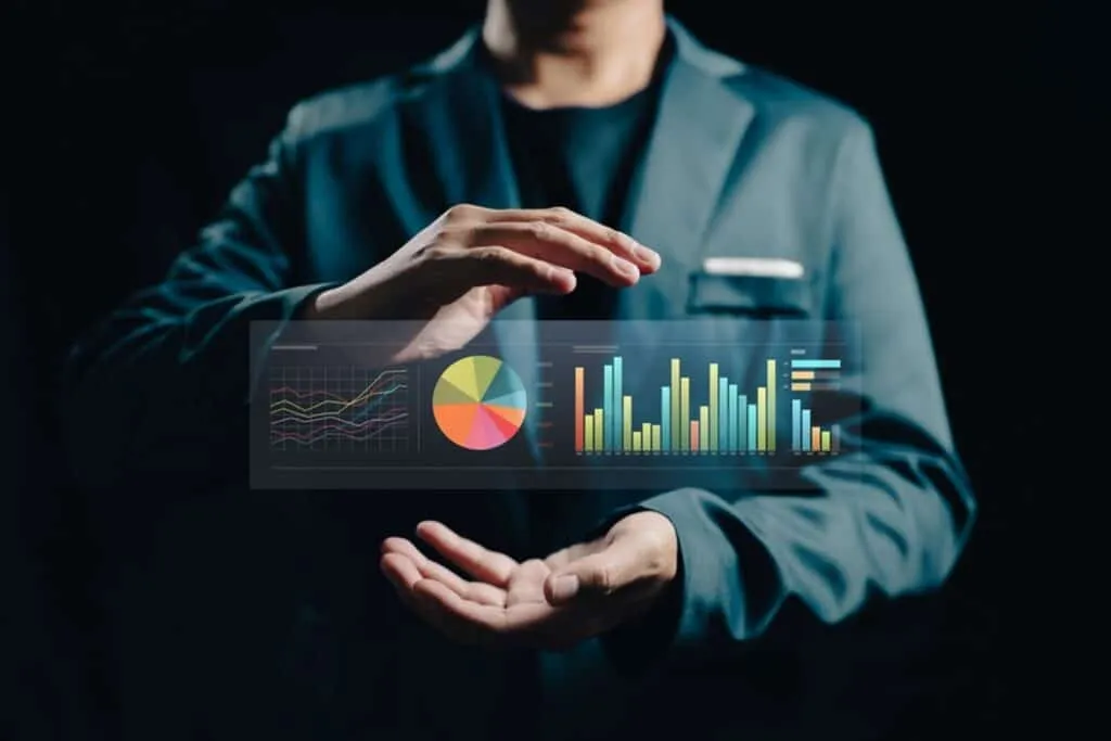 man in suit with hands encircling a table of charts and graphs